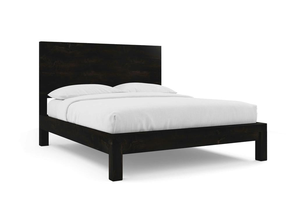 The Sawyer Bed - Charred Ember on Alder by James+James features a modern dark wood platform design with a tall headboard, white bedding, and two pillows, shown on a plain white background.