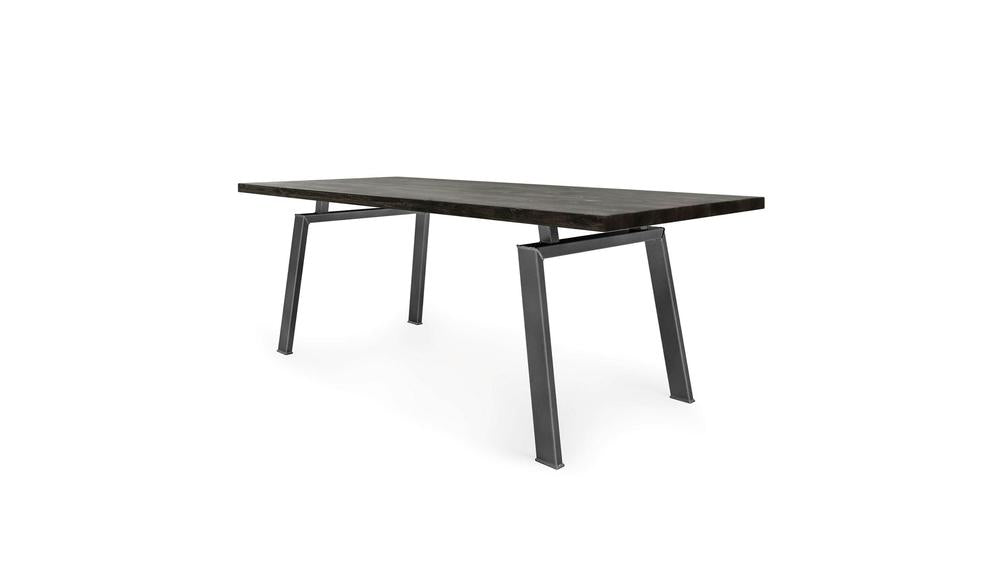 The Fulton Dining Table - Charred Ember by James+James is a minimalist rectangular table featuring a dark, charred wooden top and angled metal legs. Its design showcases clean lines and a contemporary aesthetic, making it ideal for modern interiors. The sturdy metal legs enhance the table's sleek appearance while providing robust support.