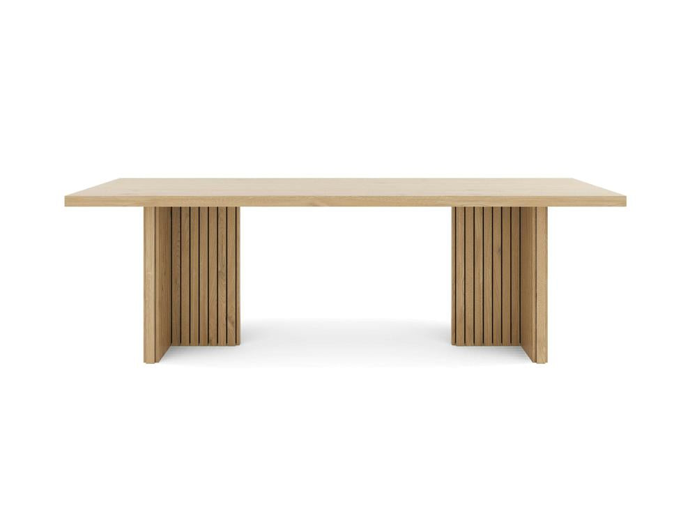 The Francesca Dining Table - Satin by James+James features a smooth rectangular wooden top. The base includes two solid vertical supports adorned with slatted wooden panel details. Its light wood finish enhances the table's minimalist, modern aesthetic, set against a plain white background.