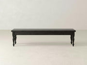 The Chateau Bench - Charred Ember by James & James, with its dark wood and turned legs, rests on a light floor against a plain wall, highlighting its minimalist rectangular design.