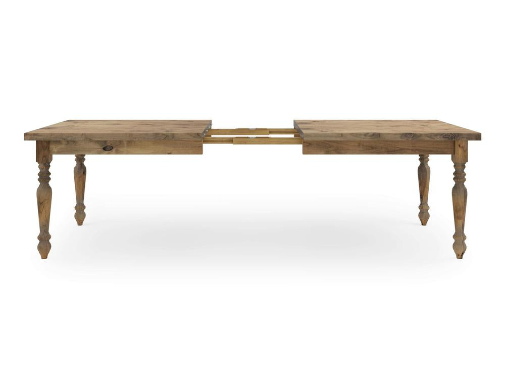 The French Country Expandable Dining Table - Harvest Wheat by James+James features a rustic wooden design with a natural finish and four turned legs. The table includes an extendable middle section, displayed partially extended to reveal the extension mechanism.
