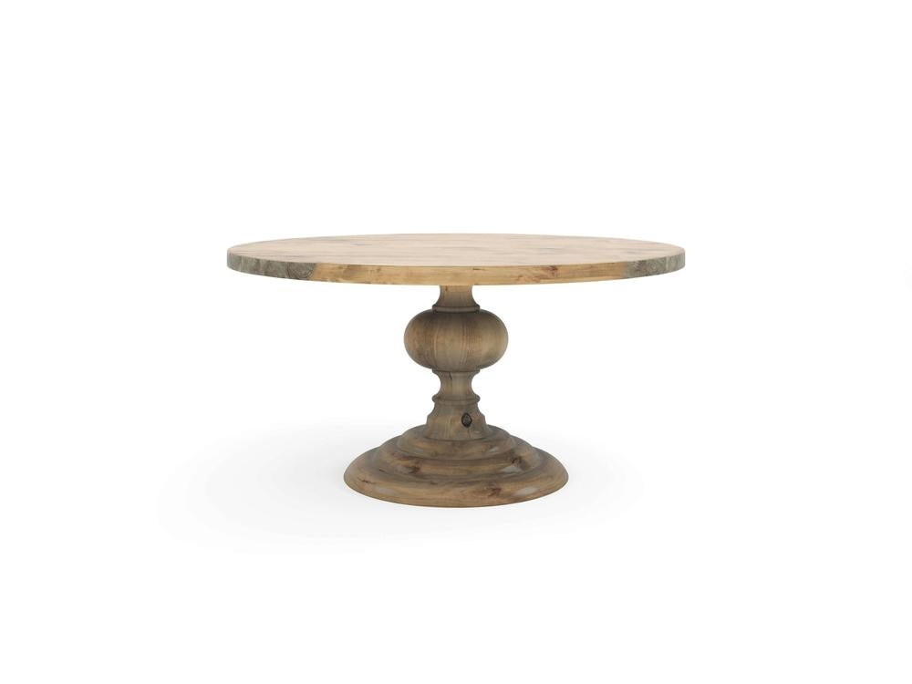 The Josephine Round Dining Table - Harvest Wheat by James+James features a smooth, round wooden top and an ornately carved single pedestal base. The natural wood finish showcases visible grain patterns that lend the table a rustic yet elegant look. The wide base of the pedestal ensures stable support for the tabletop.