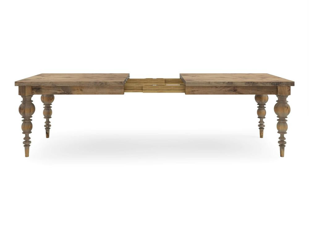 The Bailey Expandable Dining Table - Harvest Wheat by James+James showcases a rustic finish and ornate, turned legs. It is depicted in an extended position with a leaf piece in the middle, emphasizing the extension mechanism against a plain white background.