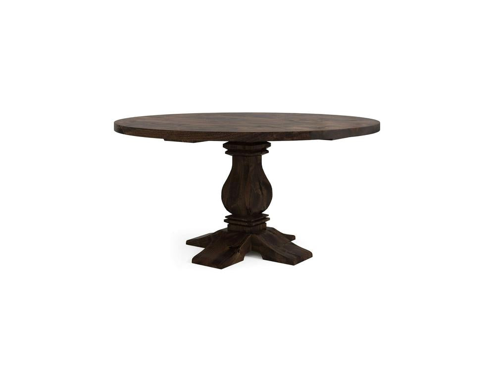The Heirloom Round Dining Table - Tobacco by James+James is a stunning piece with a dark brown finish. It boasts a thick, solid tabletop and an ornate single pedestal base, featuring four carved legs that extend outward for support. The design is both rustic and elegant, placed against a plain white background.