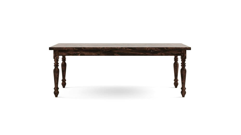 The James+James French Country Dining Table - Tobacco is displayed against a white background. This wooden table features a dark brown finish, a rectangular top, and four intricately carved, tapered legs. The overall style is rustic and traditional.