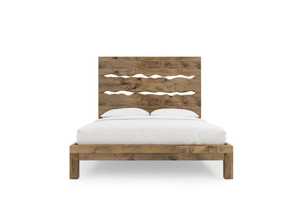The James+James Live Edge Bed - Harvest Wheat on Alder is a wooden bed frame with a large headboard and wavy cutout designs, shown with a white mattress, pillows, and bedding against a plain white background.