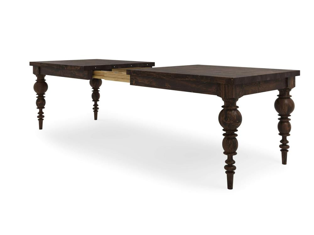 The Bailey Expandable Dining Table in Tobacco finish from James+James features intricately carved spindle legs. Its middle section extends, revealing a lighter wooden extension mechanism underneath. This table combines classic craftsmanship with functional design.