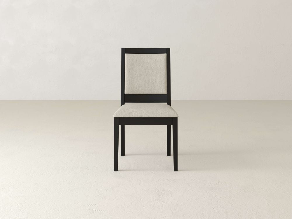 The Gina Side Dining Chair by James+James boasts a minimalist design made from maple wood, featuring padded beige seat cushions on the seat and backrest with a light gray background.